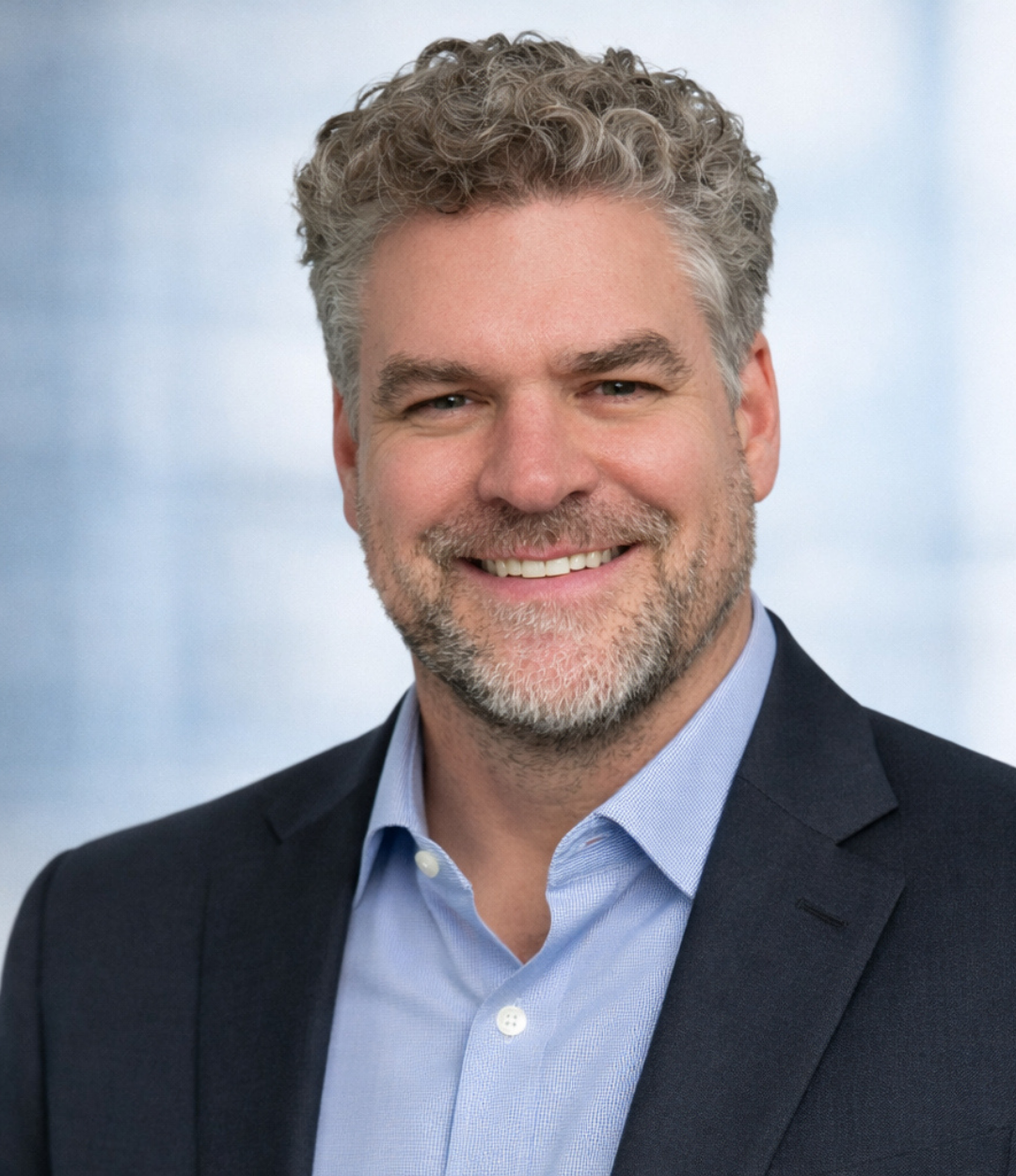 Adam Schmidt, Director of Robotics and Automation at Globe Machine Manufacturing, wearing a suit jacket and smiling in a professional executive headshot.